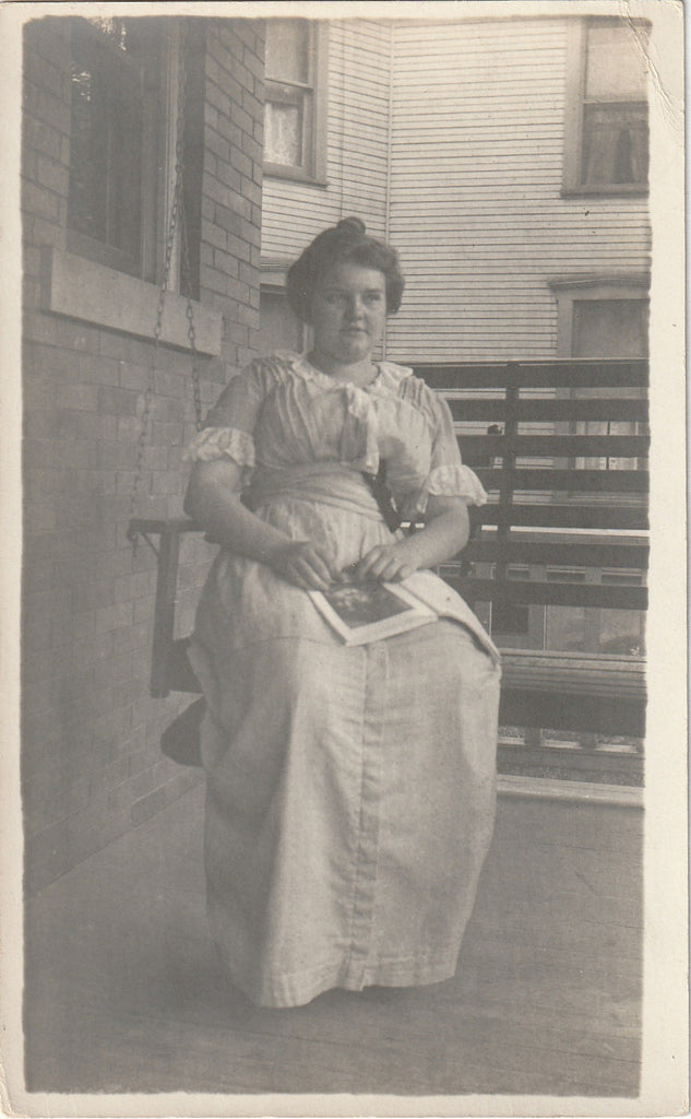 Edwardian Woman Reading Magazine on Porch Swing - RPPC, c. 1910s