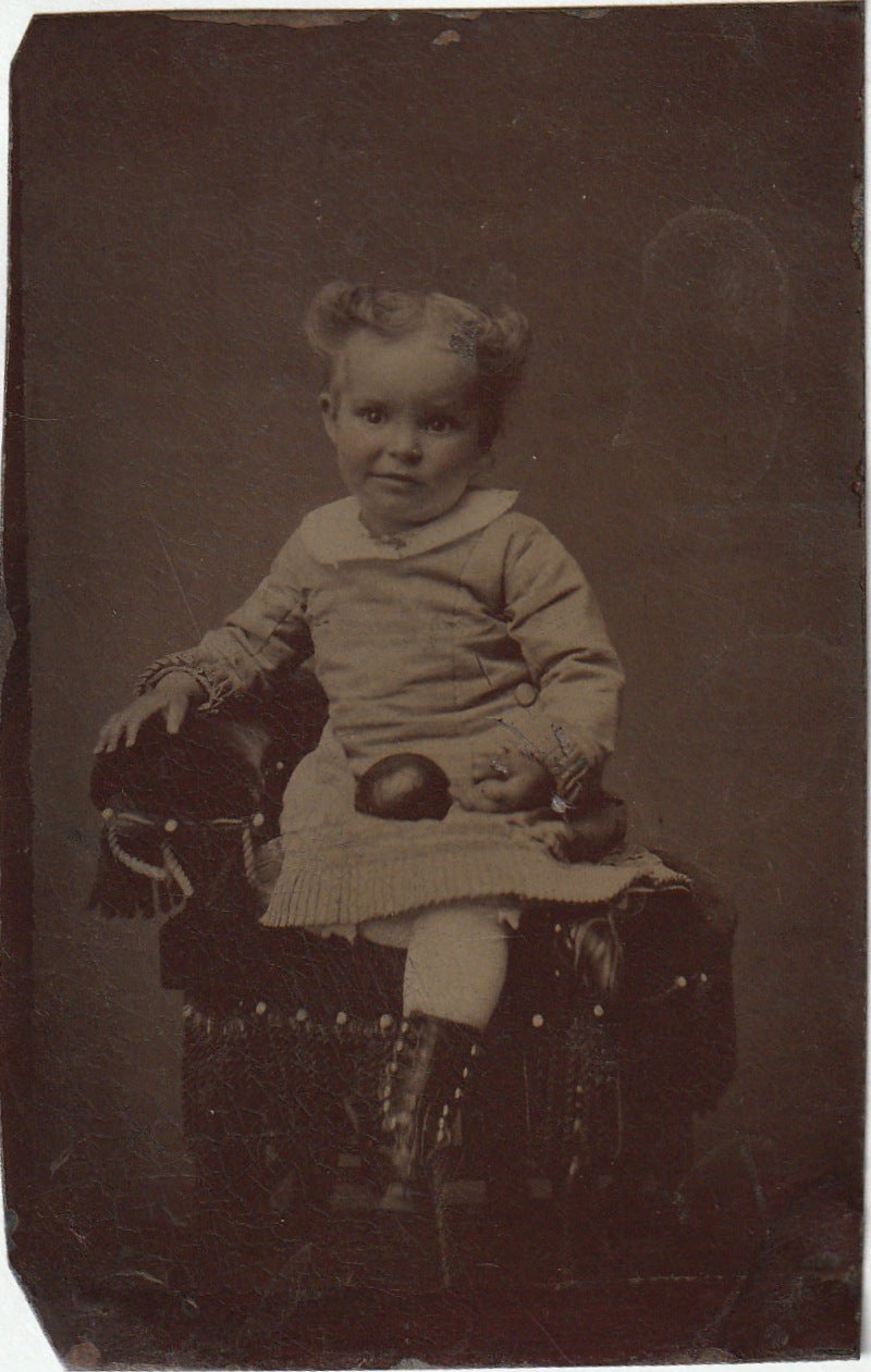 Tintype photo of young girl sitting in chair, late 1800s Tintype photo of young girl sitting in chair, late 1800s